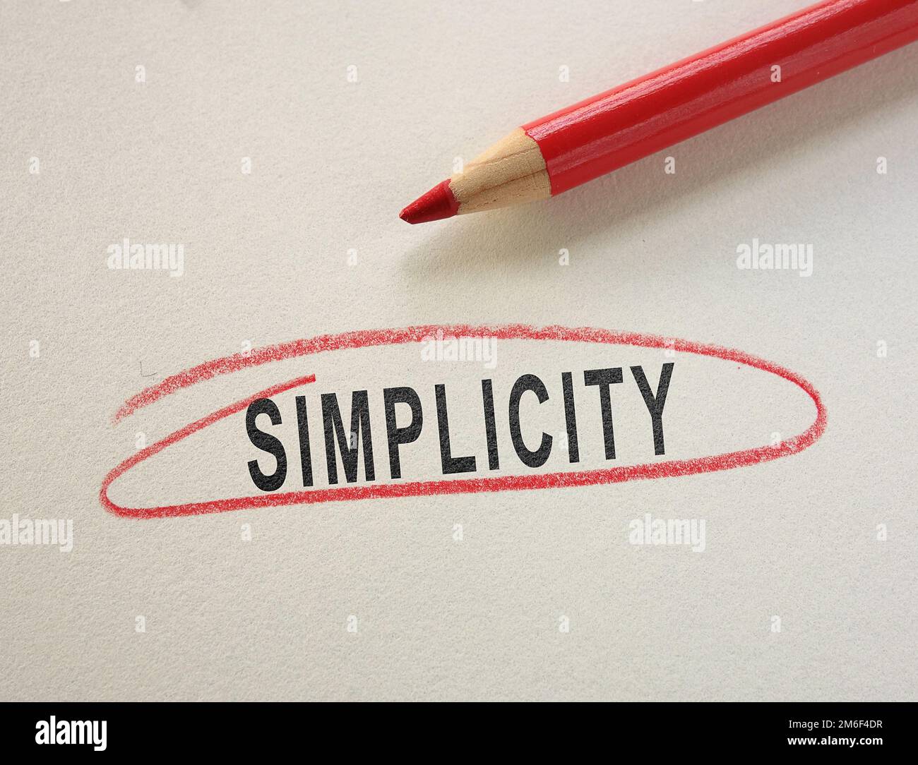 Texto de la simplicidad envuelto en un círculo de lápiz rojo sobre papel Foto de stock