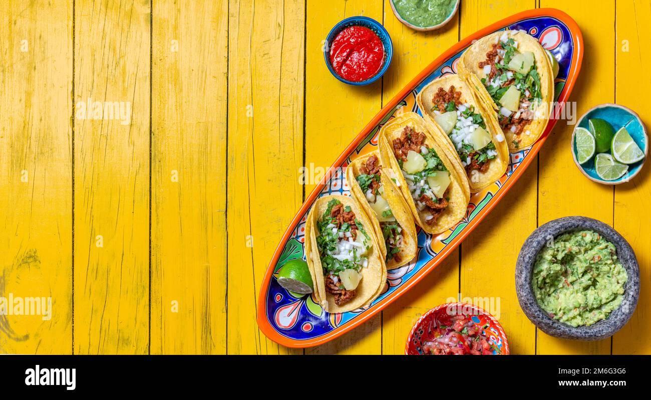 Fondo mexicano con tacos al pastor y salsas mexicanas. Fondo de madera  amarillo, espacio de copia, vista superior Fotografía de stock - Alamy