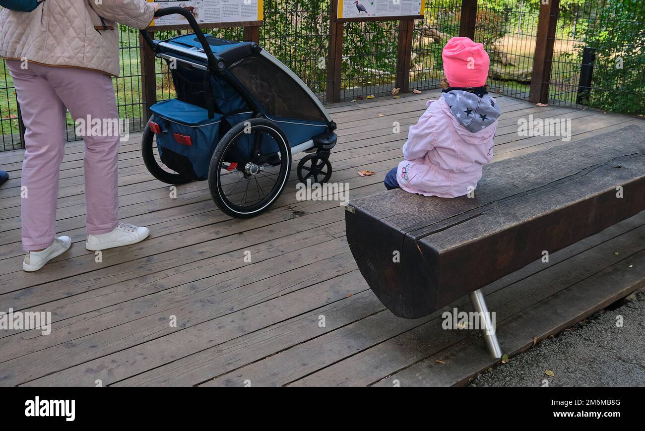 Abuela con nieta visitando zoológico con cochecito Foto de stock