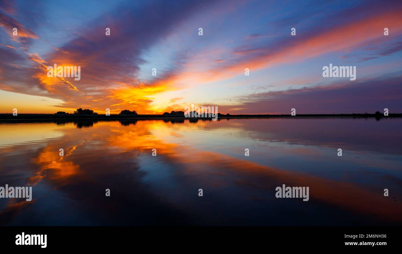 Amanecer con reflejos en el delta del Danubio en Rumania Foto de stock