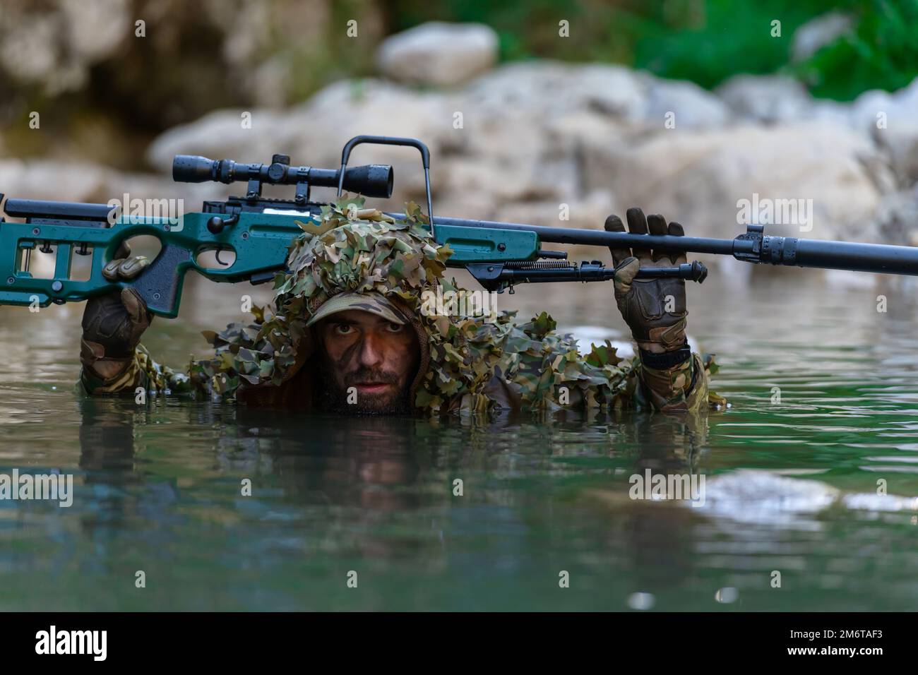 un militar hombre o airsoft jugador en un camuflaje traje furtivo el río y  objetivos desde un francotirador rifle a el lado o a objetivo. 31027903  Foto de stock en Vecteezy