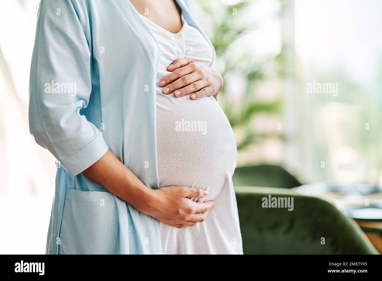 Primer plano de mujer embarazada sosteniendo su vientre. Concepto de cuidado de la maternidad Foto de stock