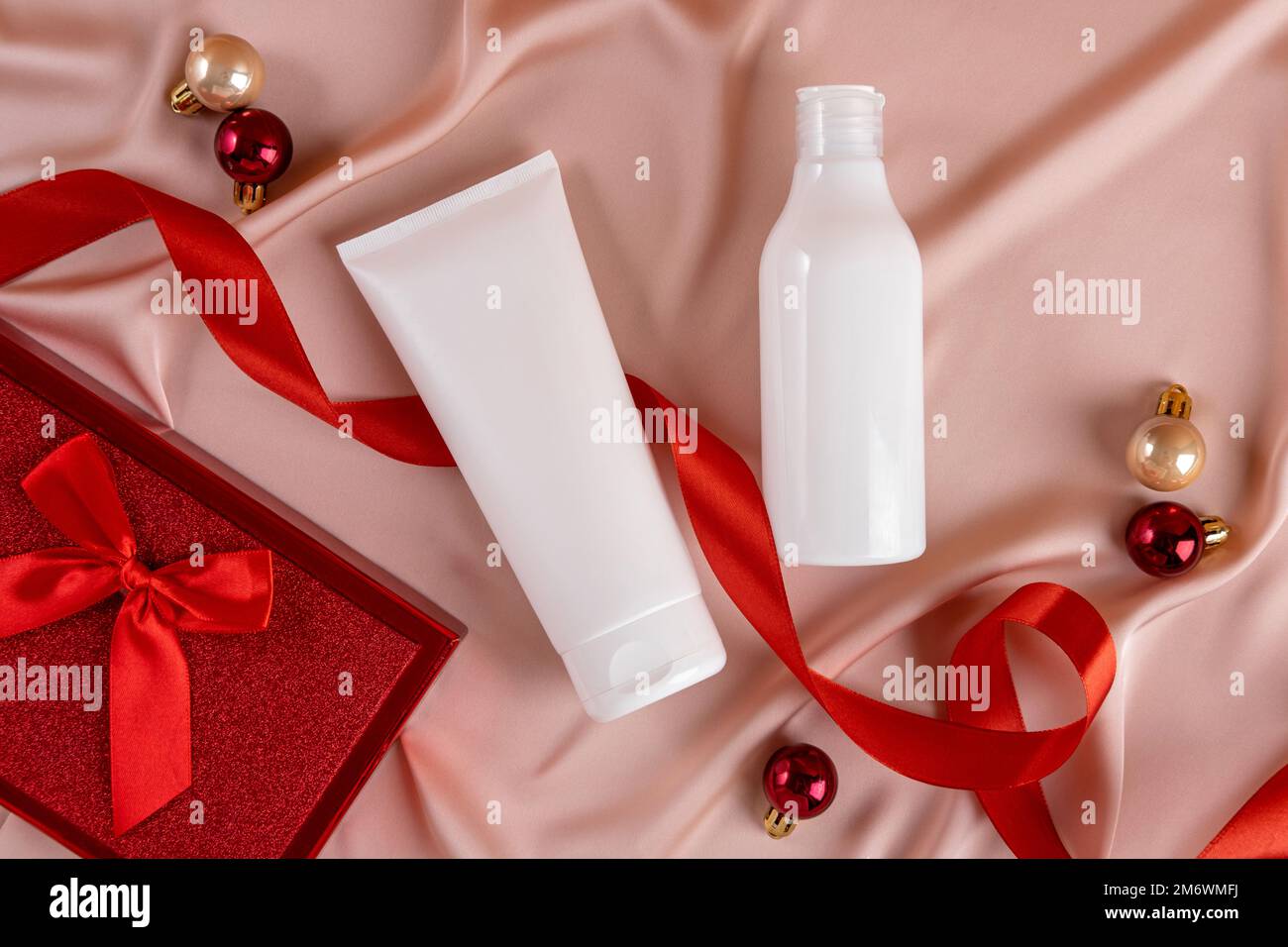 Botella blanca producto cosmético sobre fondo textil. Venta de Navidad de concepto de producto de belleza. Vista superior con lugar para el texto. Foto de stock
