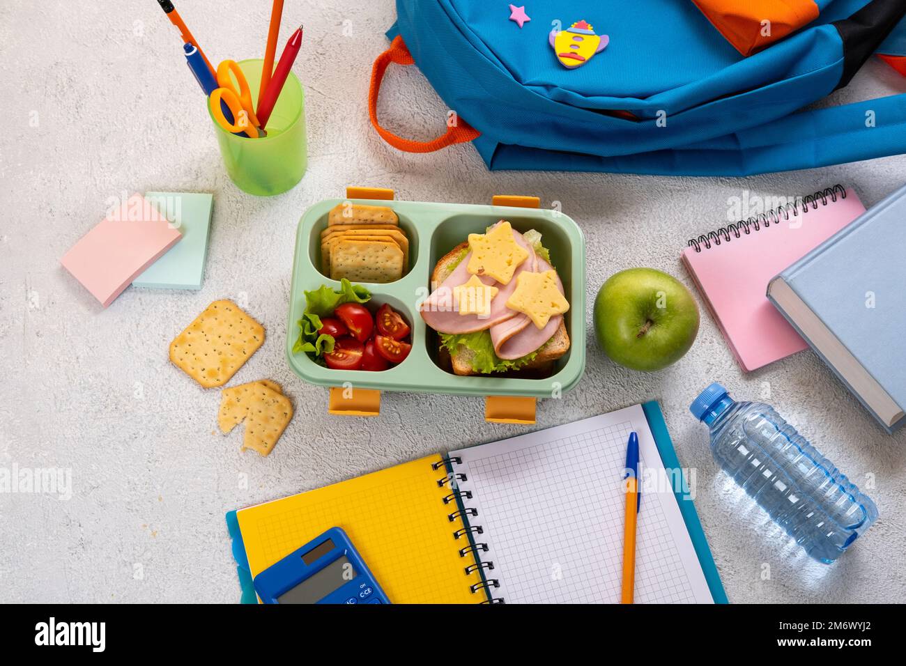 Caja de almuerzo escolar saludable con sándwich y ensalada en el lugar de  trabajo cerca de la mochila. Útiles escolares, libros, manzana y una  botella de w Fotografía de stock - Alamy