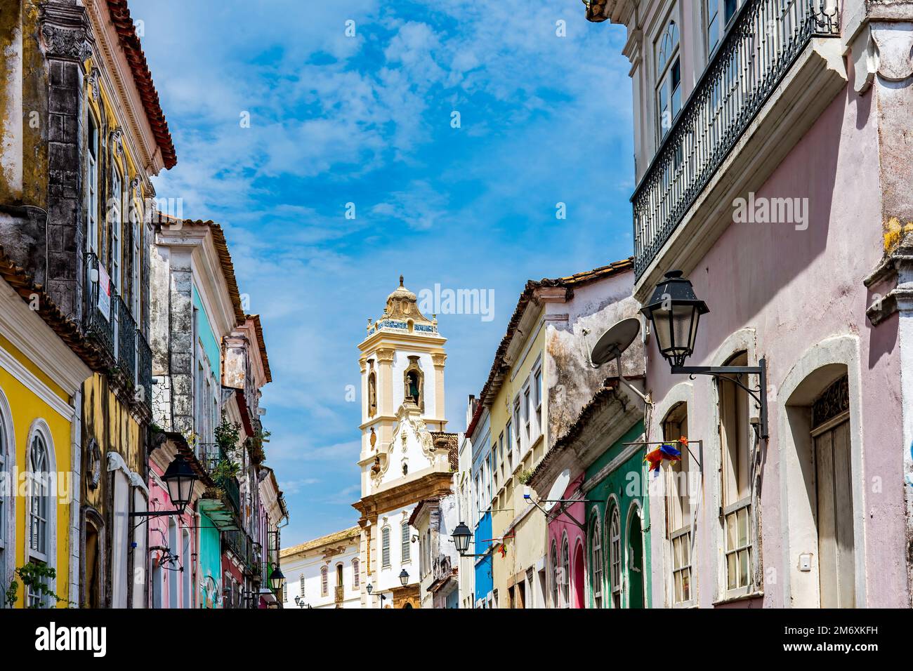 Casas antiguas con fachadas coloridas y torre de la iglesia histórica en Pelourinho Foto de stock