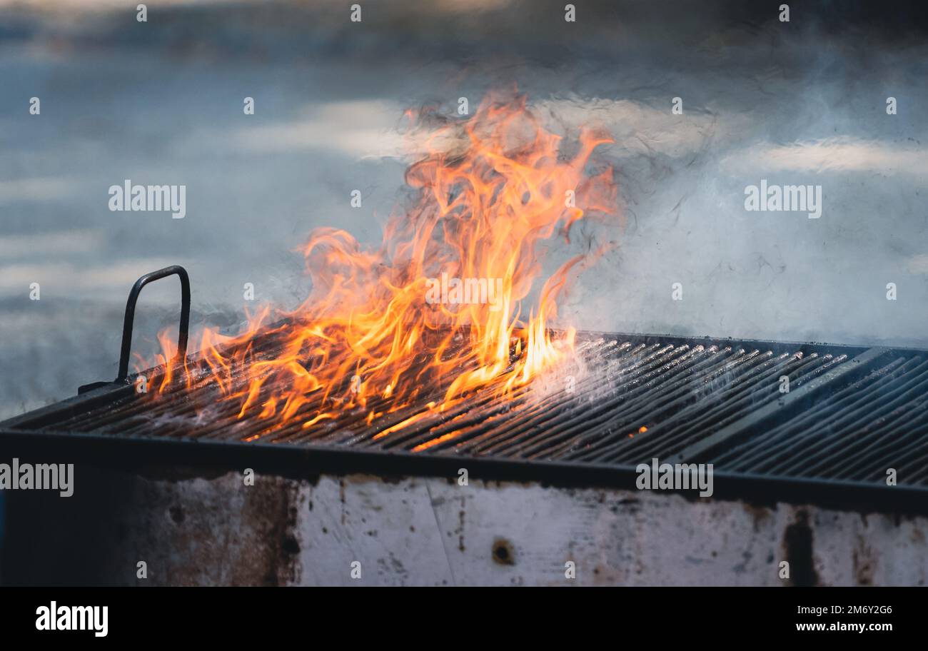 https://c8.alamy.com/compes/2m6y2g6/vista-frontal-de-una-parrilla-metalica-grande-y-antigua-con-llamas-de-fuego-y-humo-saliendo-2m6y2g6.jpg