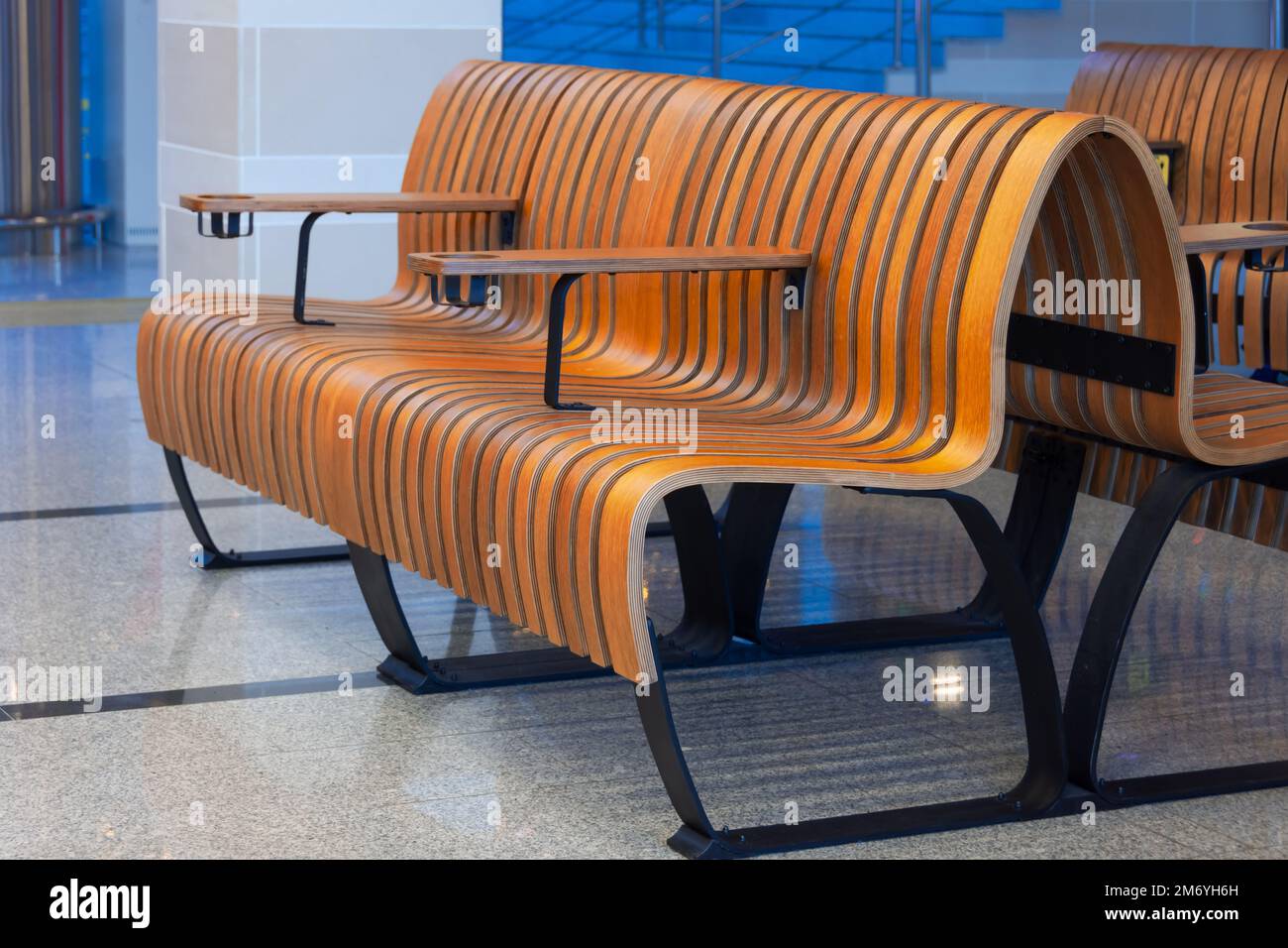 Bancos de madera y líneas de madera tallada en la sala de espera de pasajeros Foto de stock