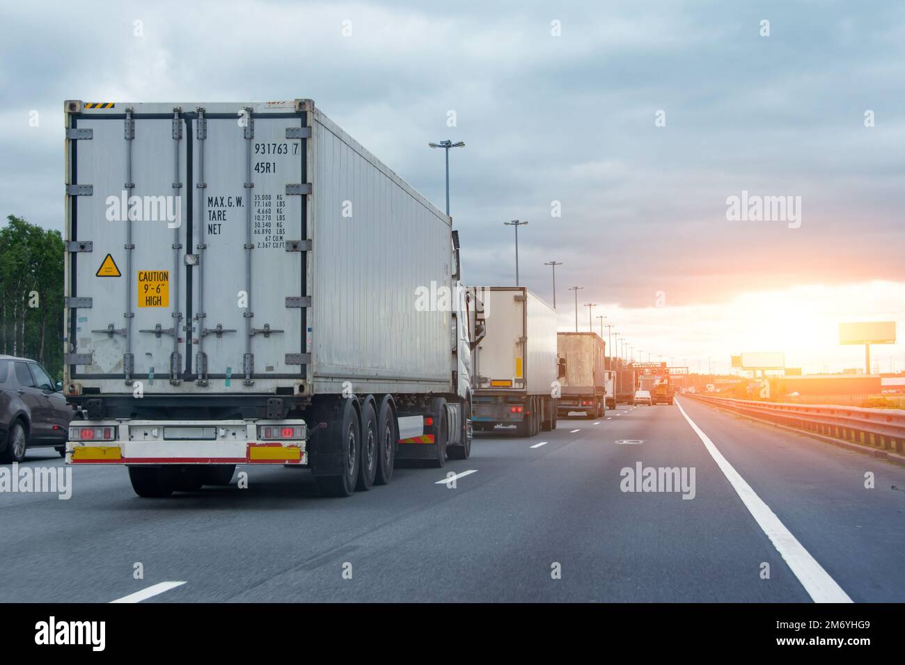 Camiones de camiones de coches en el atasco de tráfico en la zona fronteriza de la aduana, hora de la puesta del sol Foto de stock
