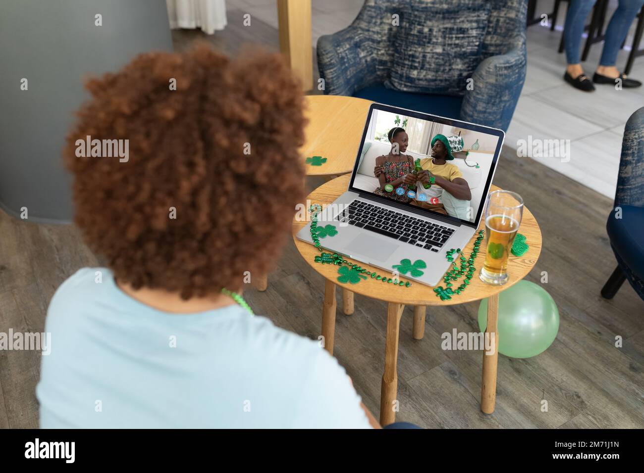 Hombre afroamericano que tiene una videoconferencia en el ordenador portátil en un bar Foto de stock