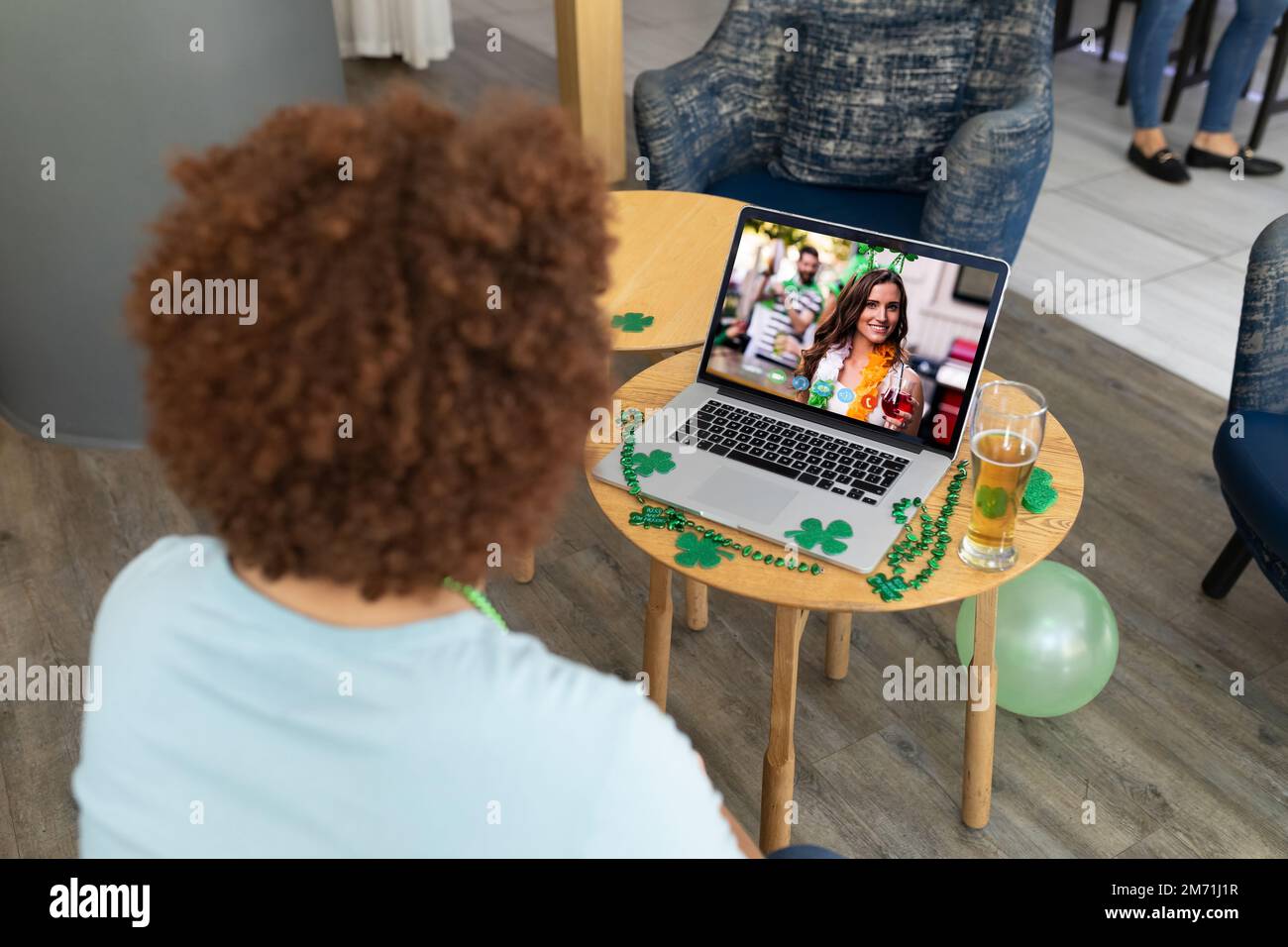 Hombre afroamericano que tiene una videoconferencia en el ordenador portátil en un bar Foto de stock