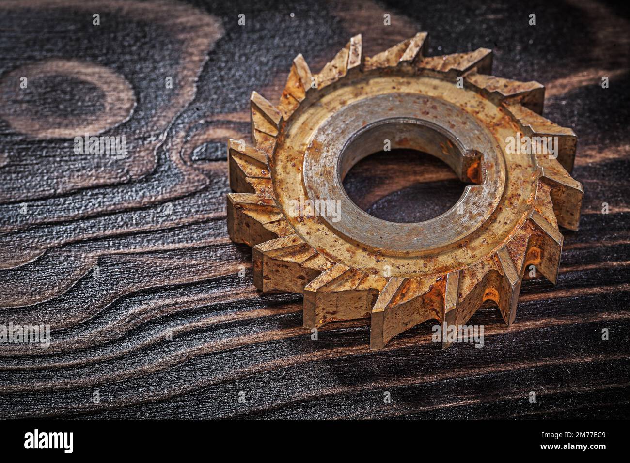 Cortador rotatorio oxidado en el concepto de construcción de fondo de madera vintage. Foto de stock