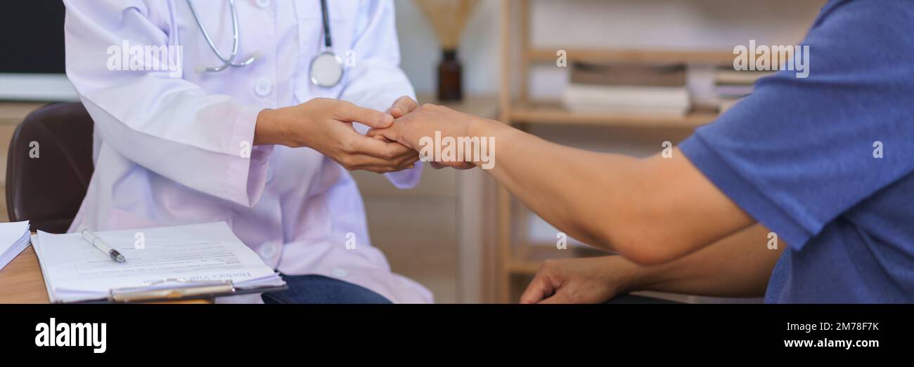 Concepto de salud, cuidador de la mujer toca la mano para alentar al hombre mayor después de decir el resultado de la salud. Foto de stock