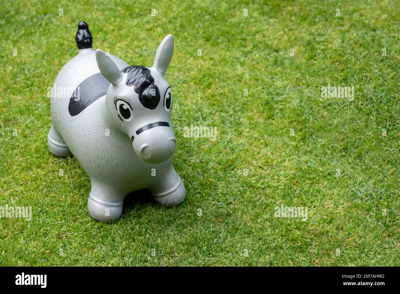 caballo montable para el partido de los niños en un jardín con hierba verde. Foto de stock