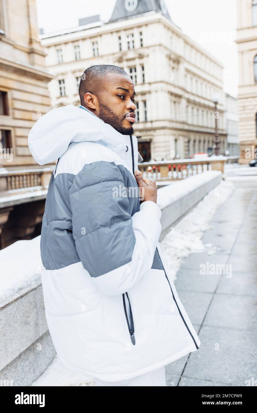 Hombre africano joven en ropa blanca y azul casual, suéter rayado. Retrato  de la moda de la calle de la temporada de invierno con la nieve. Estilo de  vida, concepto de vida