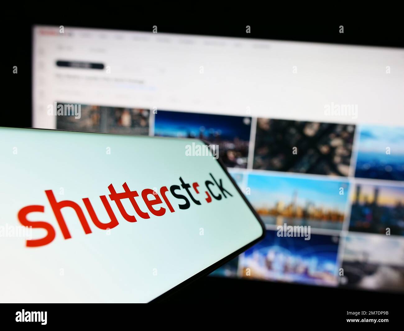 Teléfono móvil con el logotipo de la compañía estadounidense de fotografía de stock Shutterstock Inc. En la pantalla delante del sitio web. Enfoque en el centro derecho de la pantalla del teléfono. Foto de stock