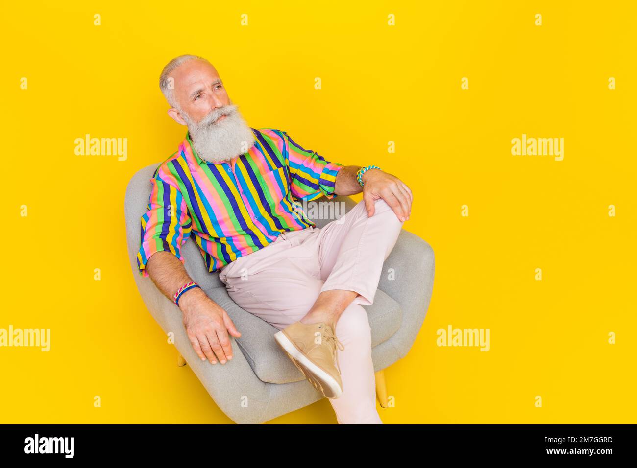 Retrato de la persona anciana guapa se sienta cómodo sillón mirar espacio  vacío aislado en fondo de color amarillo Fotografía de stock - Alamy