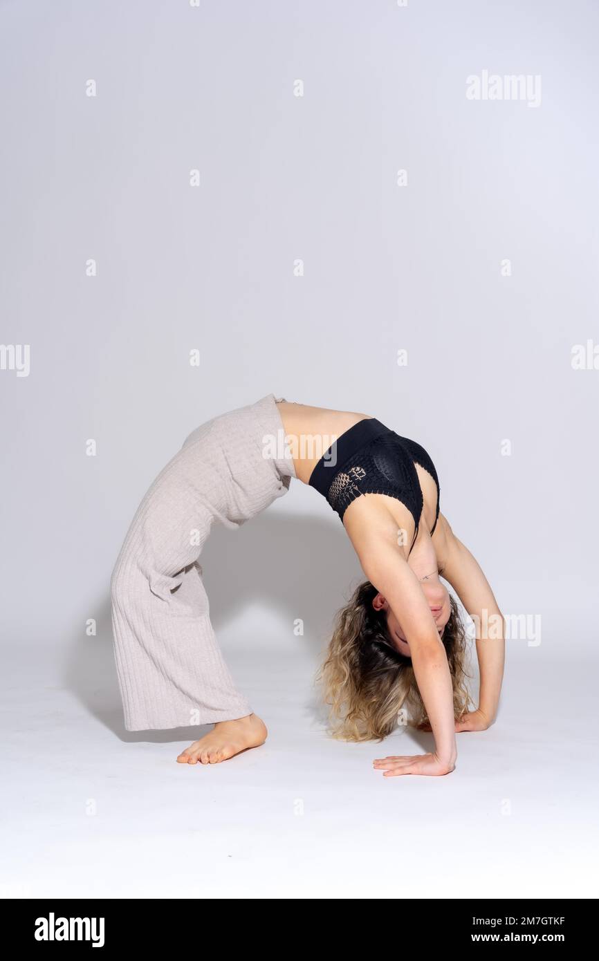 Joven bailarina en sesión de fotos de estudio con un fondo blanco, ballet, haciendo un puente handstand Foto de stock