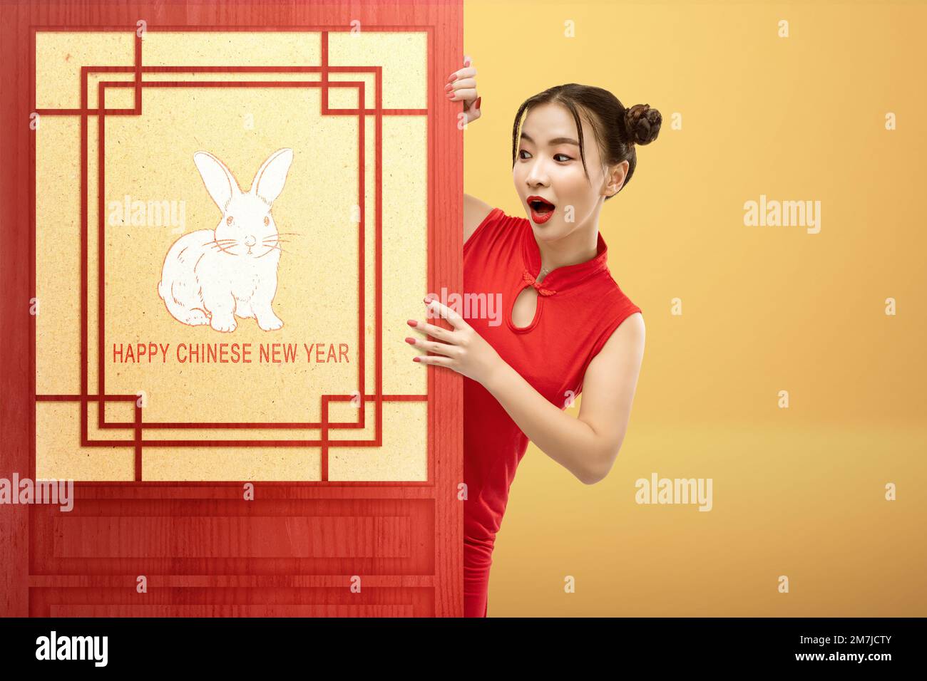 Una mujer china asiática en un vestido de cheongsam de pie detrás de la  pared con un símbolo de conejo. Feliz año nuevo chino. Año Nuevo Chino del  Conejo Fotografía de stock -