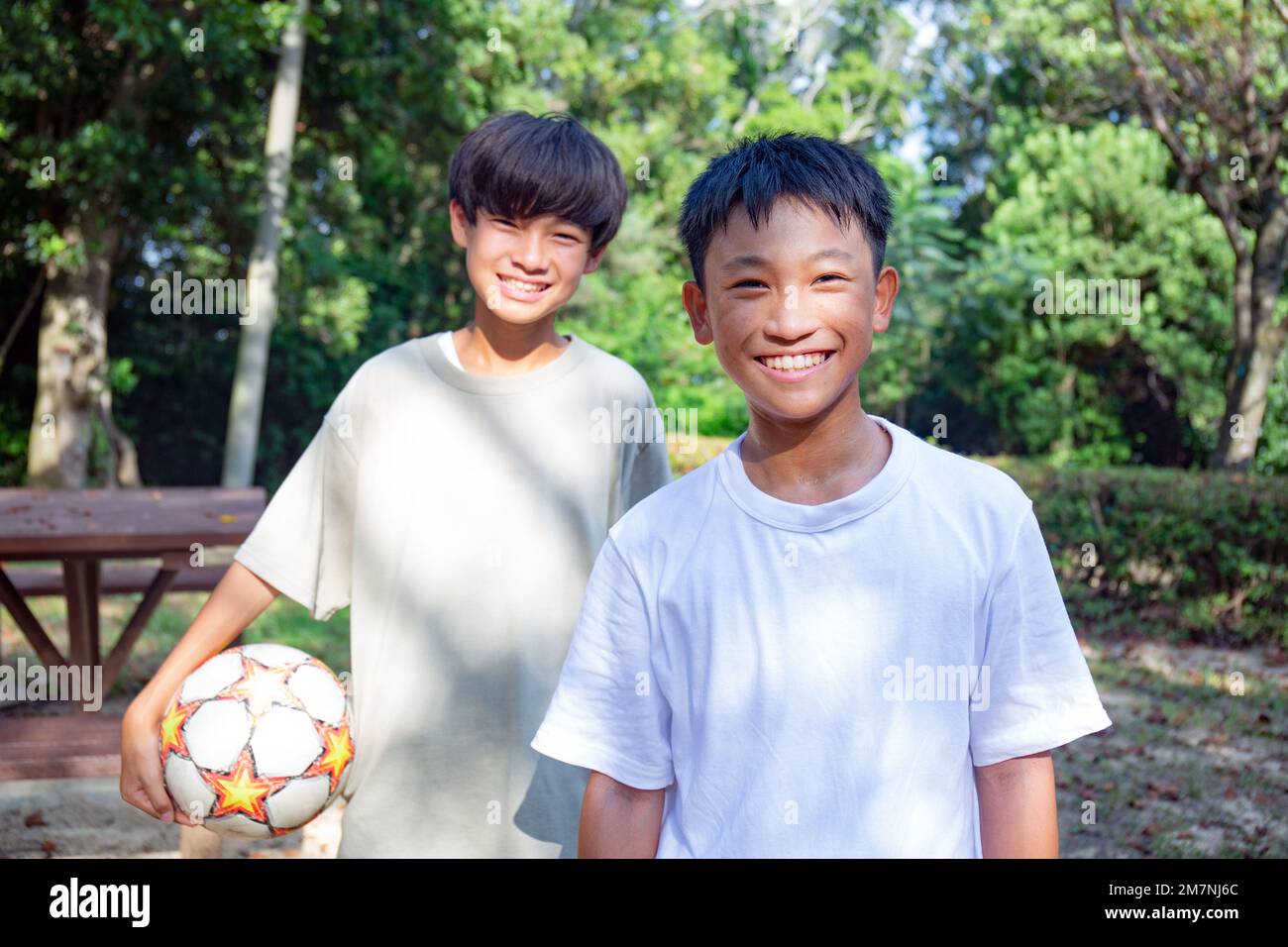 Dos niños de 13 años en un parque con un fútbol en verano. Foto de stock