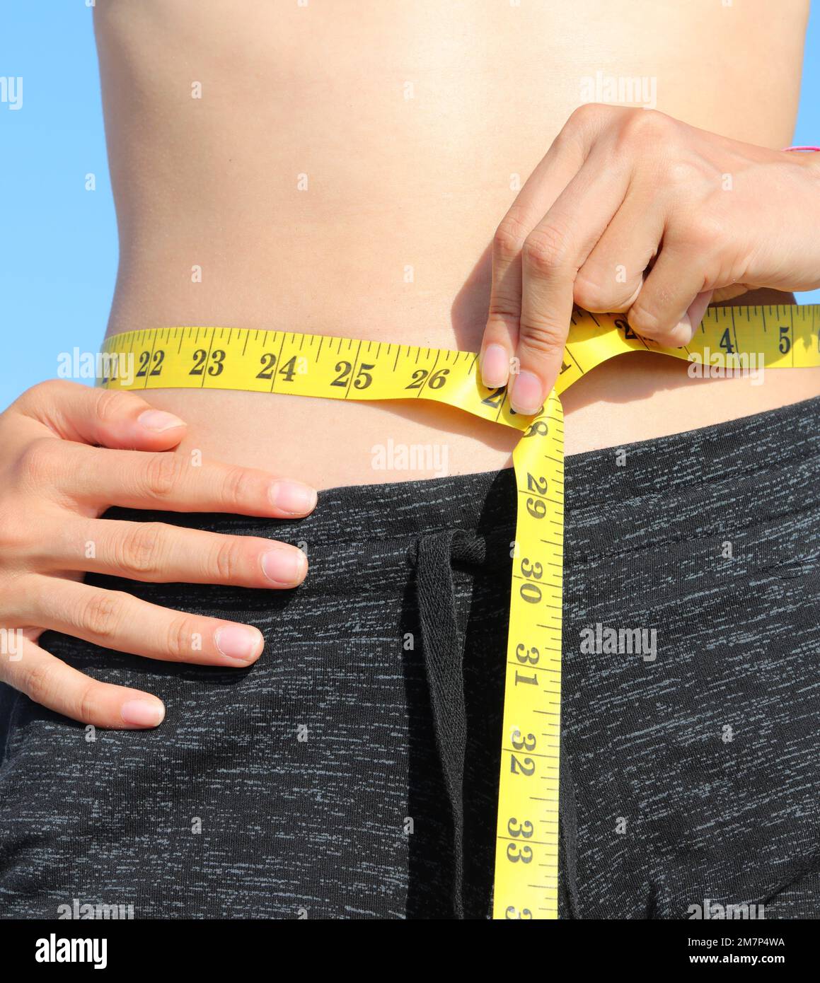 medida de cintura de vientre de niña con cinta amarilla y medida en  pulgadas Fotografía de stock - Alamy