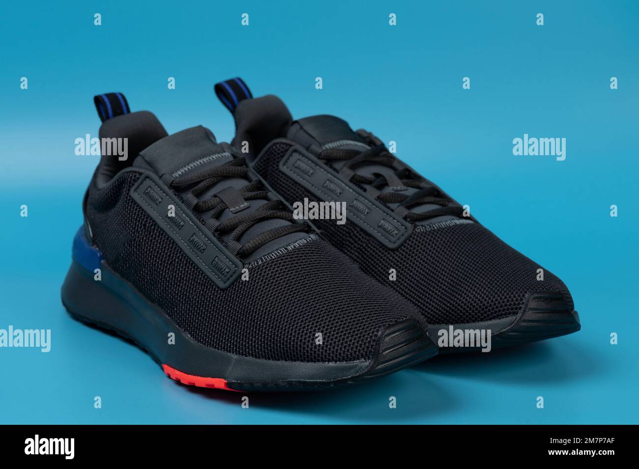 Zapatos corrientes negros aislados en fondo azul del estudio Fotografía de  stock - Alamy