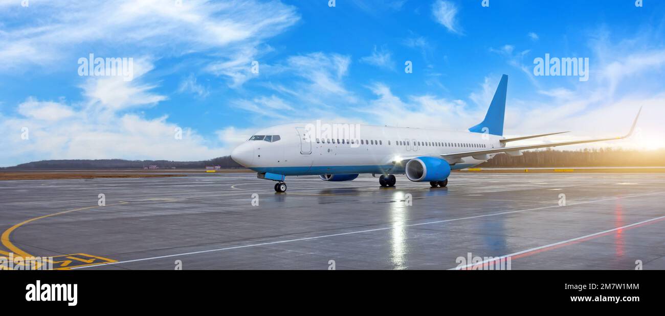 El avión de pasajeros a reacción de línea viaja en la carretera de dirección del aeródromo después de aterrizar en la pista, bandera amplia vista panorámica Foto de stock