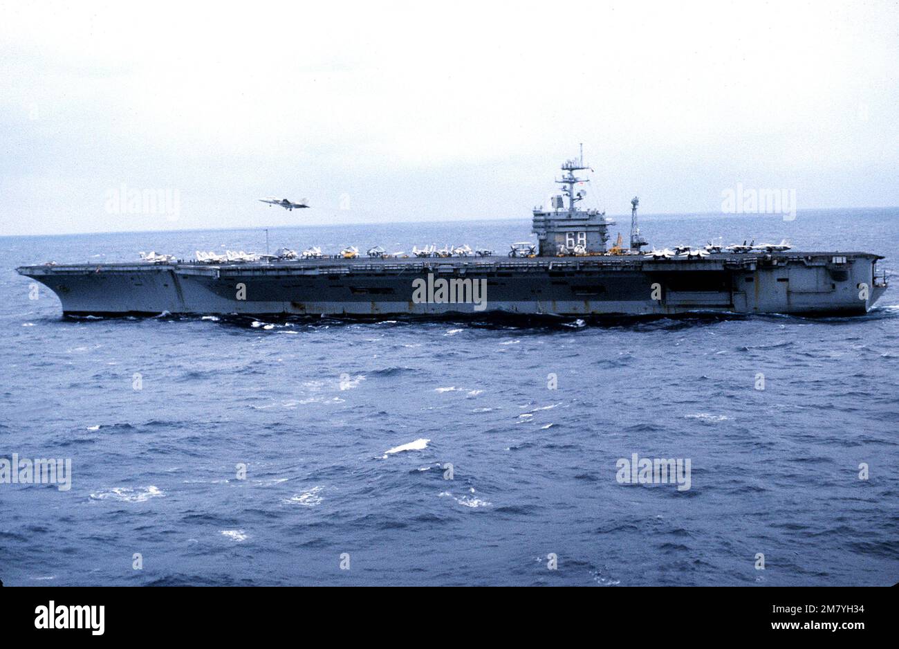 Una vista del haz del puerto del portaaviones propulsión USS NIMITZ (CVN-68) en marcha. Un avión F-14 Tomcat está en vuelo por encima de la aerolínea. País: Mar Mediterráneo (MED