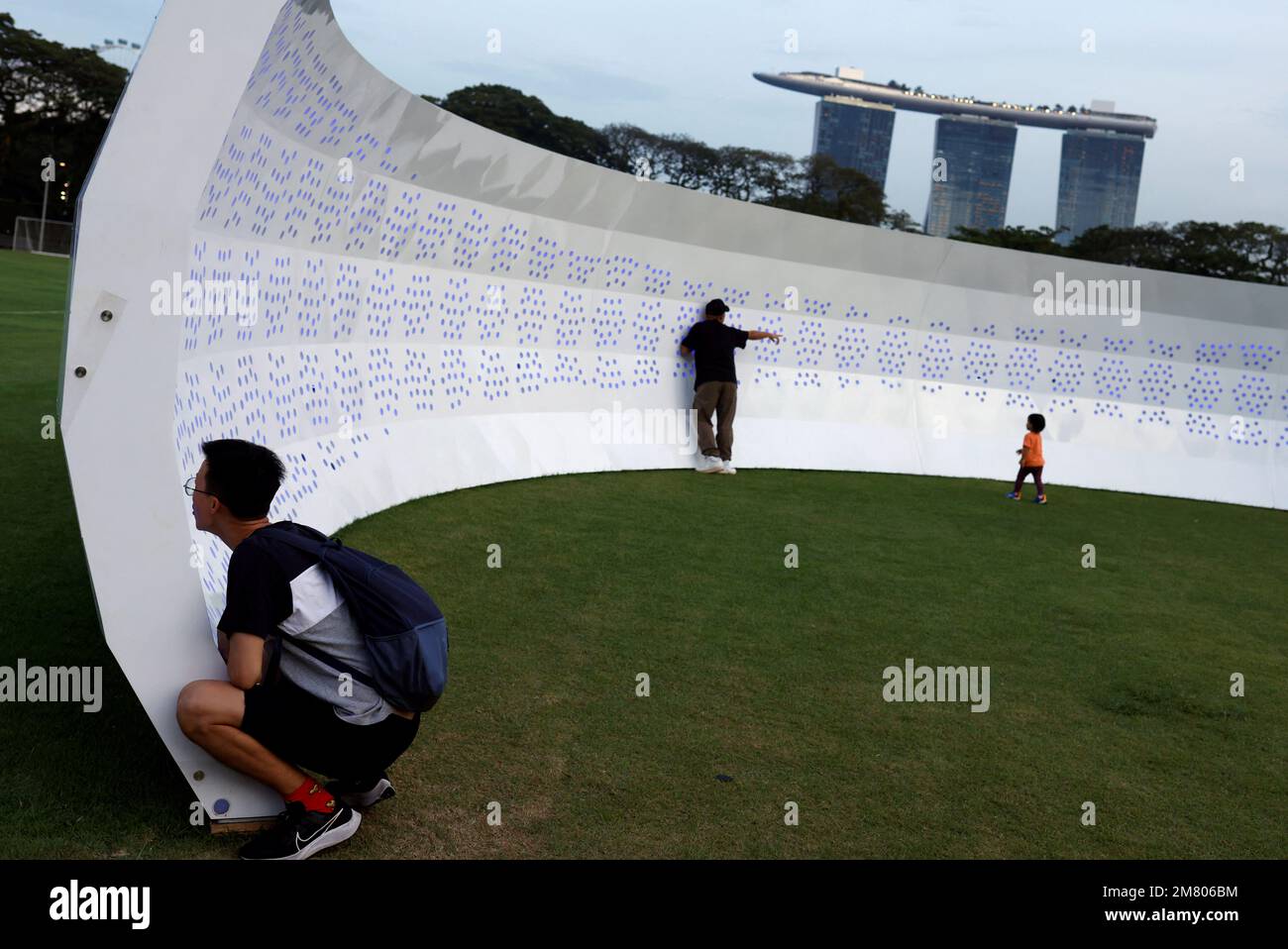 Las personas interactúan con 'Hearing Padang', una instalación de arte acústico que permite que el sonido viaje de un extremo a otro, en Singapur el 11 de enero de 2023. REUTERS/Edgar Su Foto de stock