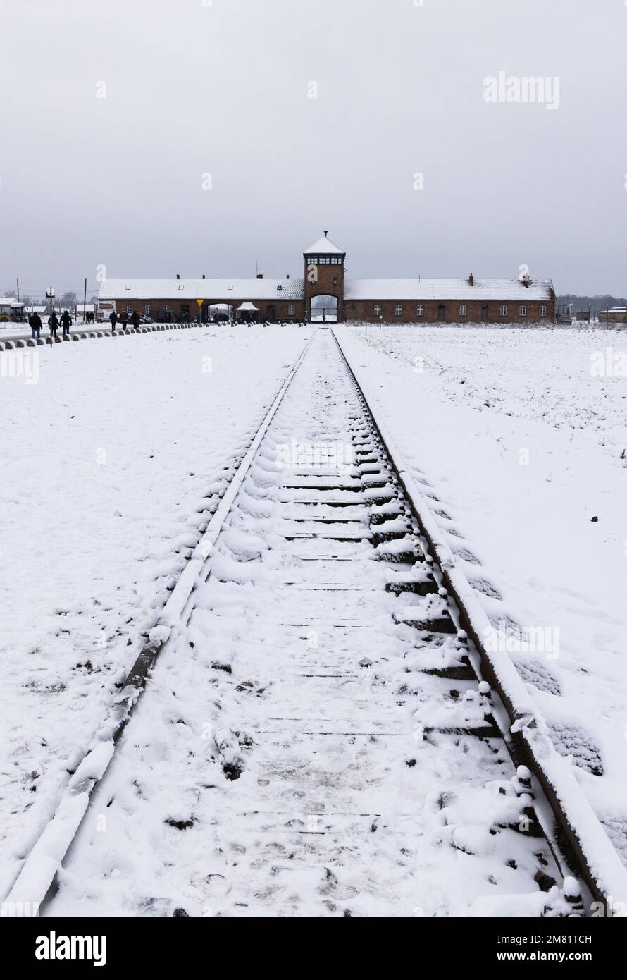 Campo de concentración de Auschwitz Birkenau; puerta de entrada sombría y línea de ferrocarril en la nieve de invierno; Auschwitz, Oswiecim Polonia; campo de exterminio nazi de la Segunda Guerra Mundial. Foto de stock