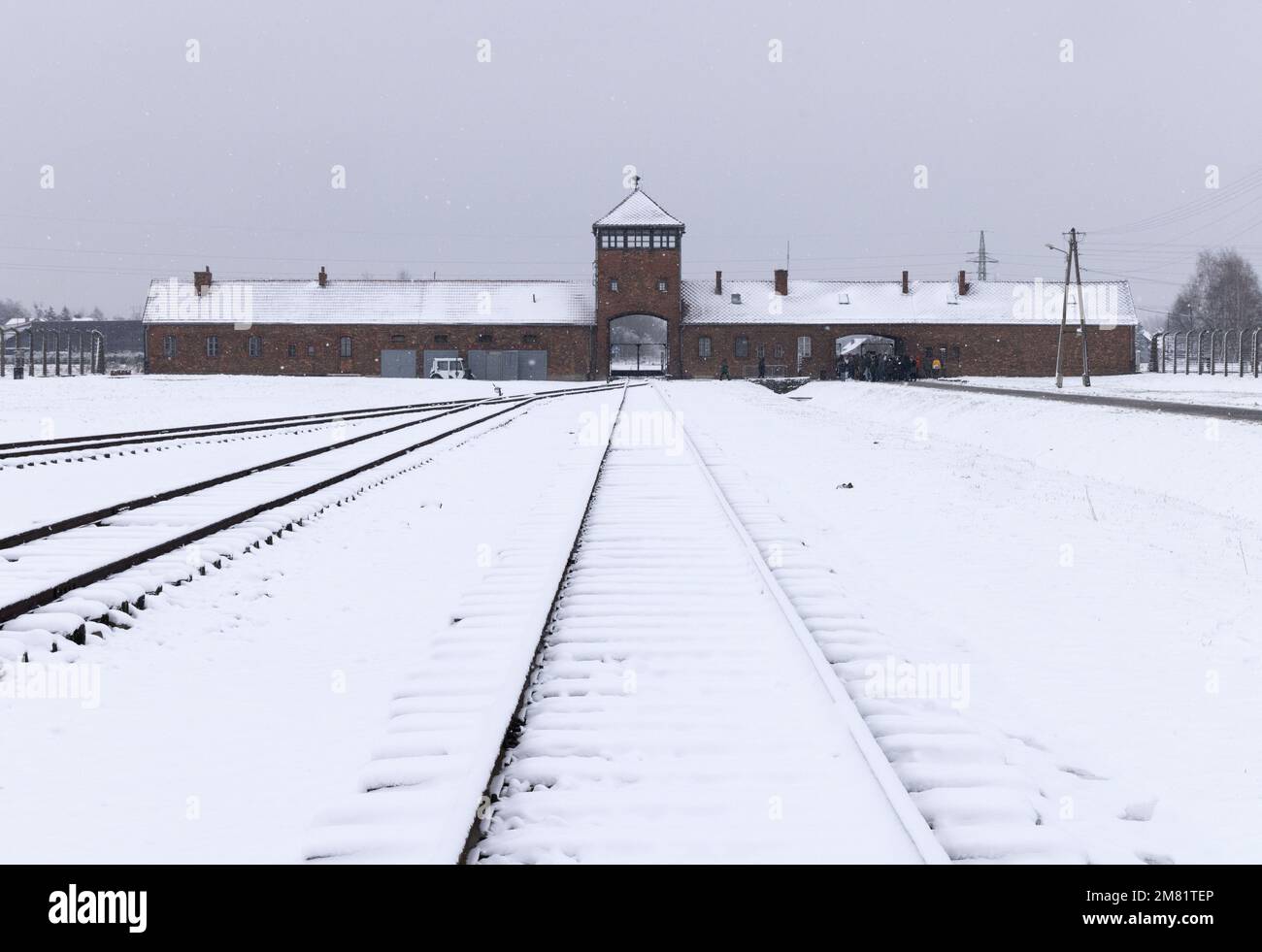 Campo de concentración de Auschwitz Birkenau; puerta de entrada sombría y línea de ferrocarril en la nieve de invierno; Auschwitz, Oswiecim Polonia; Patrimonio de la Humanidad de la UNESCO. Foto de stock