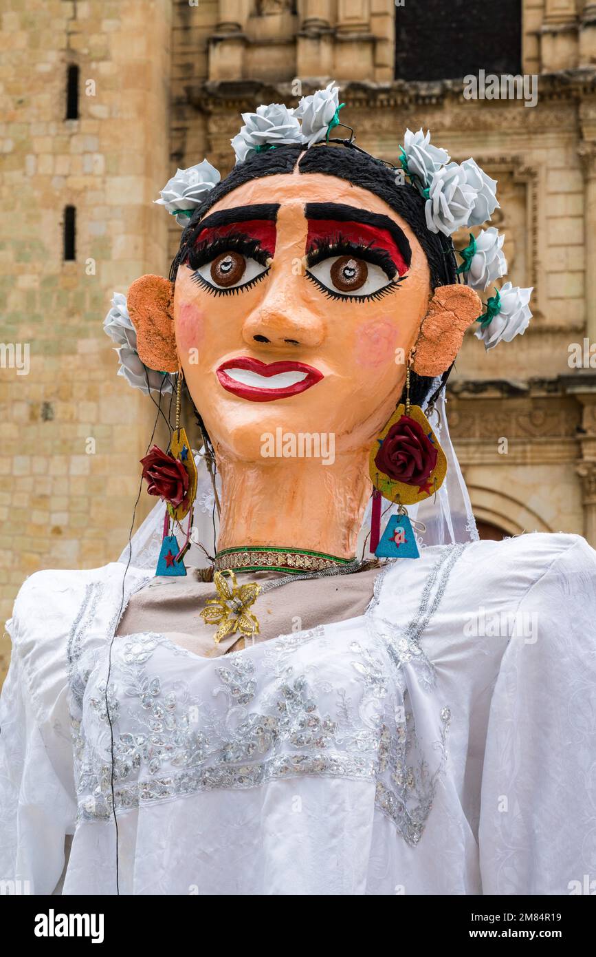Una marioneta de novia gigante en traje tradicional llamada mono de calenda  antes de una celebración de boda en Oaxaca, México. Detrás está la Iglesia  de Santo Domi Fotografía de stock -