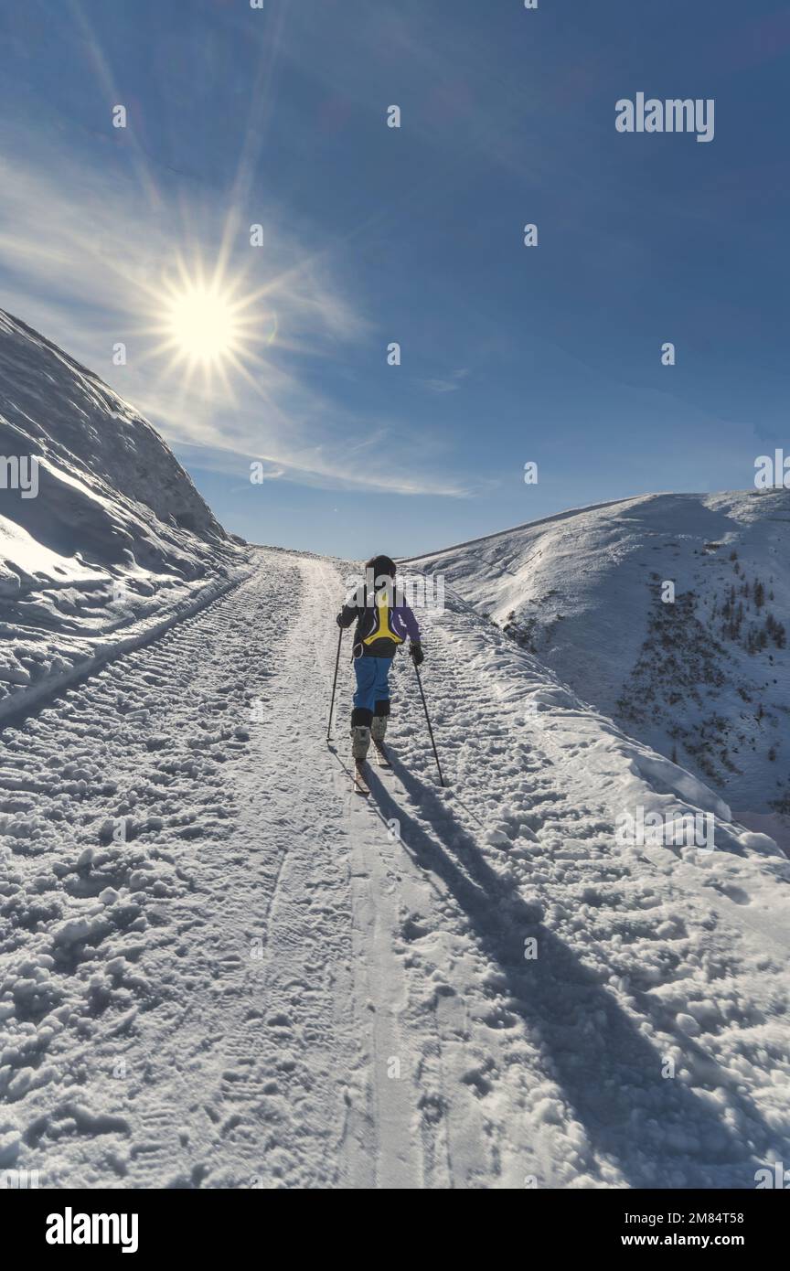 Un niño con esquís de montañismo en Una escalada en los Alpes italianos Foto de stock