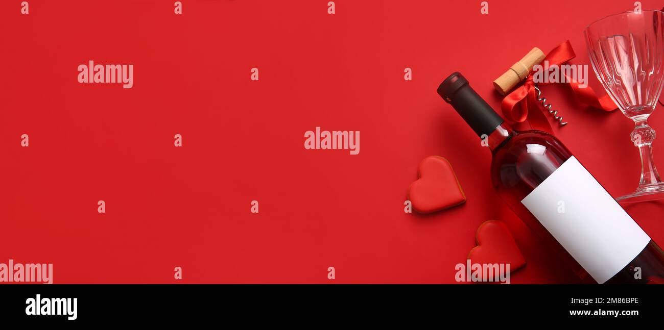 Botella de vino, vidrio, sacacorchos y galletas en forma de corazón sobre  fondo rojo con espacio para texto. Celebración del Día de San Valentín  Fotografía de stock - Alamy