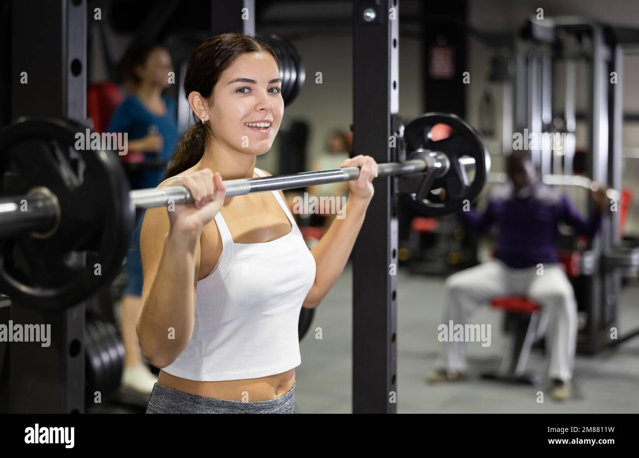 Mujer en ropa deportiva. Mujer realizando ejercicios con barbell en el  gimnasio Fotografía de stock - Alamy