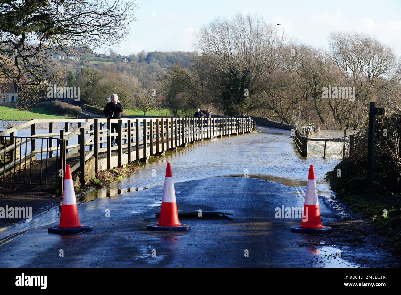 Los conos de tráfico bloquean un puente inundado por el río Avon, en Lacock, Wiltshire. Fecha de la fotografía: Viernes 13 de enero de 2023. Foto de stock