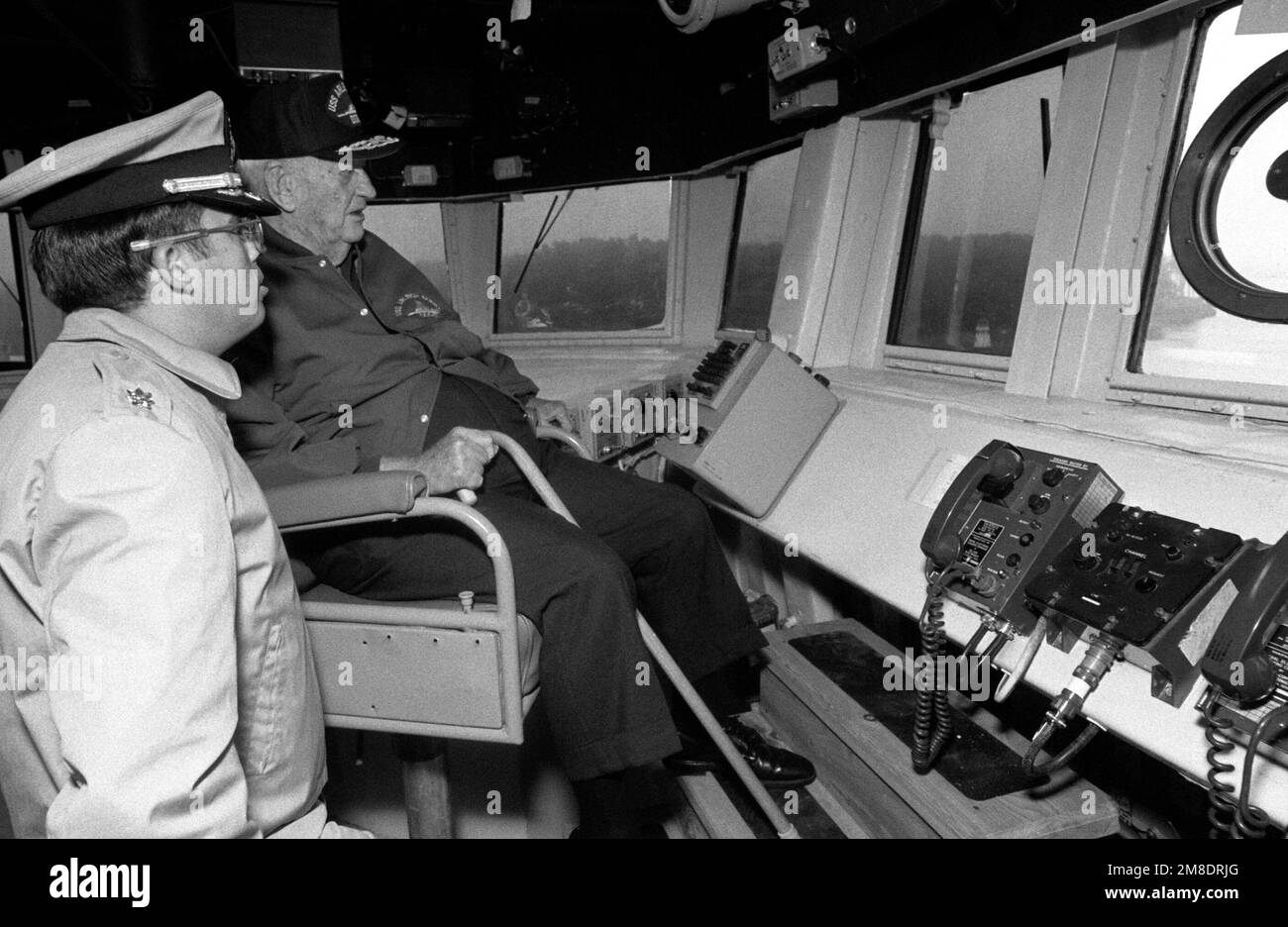 El almirante retirado Arleigh A. Burke, homónimo del destructor guiado de misiles ARLEIGH BURKE (DDG 51), y un oficial miran desde el puente durante las pruebas de mar del barco frente a la costa de Maine. El ARLEIGH BURKE es uno de los pocos barcos que ha sido nombrado por una persona viva. País: Océano Atlántico (AOC) Foto de stock