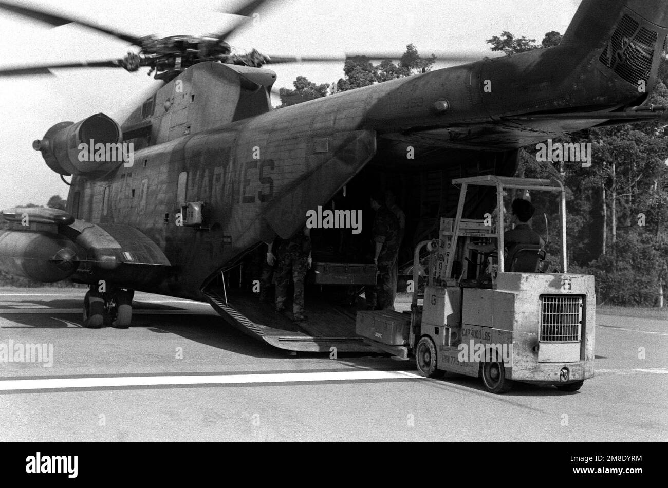 La Marina de los Estados Unidos descarga suministros desde un helicóptero CH-53D Sea Stallion durante los esfuerzos de rescate y recuperación en una zona que sufrió daños por terremotos. Base: Cabanatuan Ciudad País: Filipinas Foto de stock