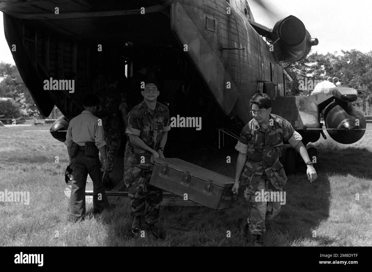 Los infantes de marina de los Estados Unidos descargan suministros de un helicóptero CH-53D Sea Stallion durante los esfuerzos de rescate y recuperación en una zona que sufrió daños por terremotos. Base: Cabanatuan Ciudad País: Filipinas Foto de stock