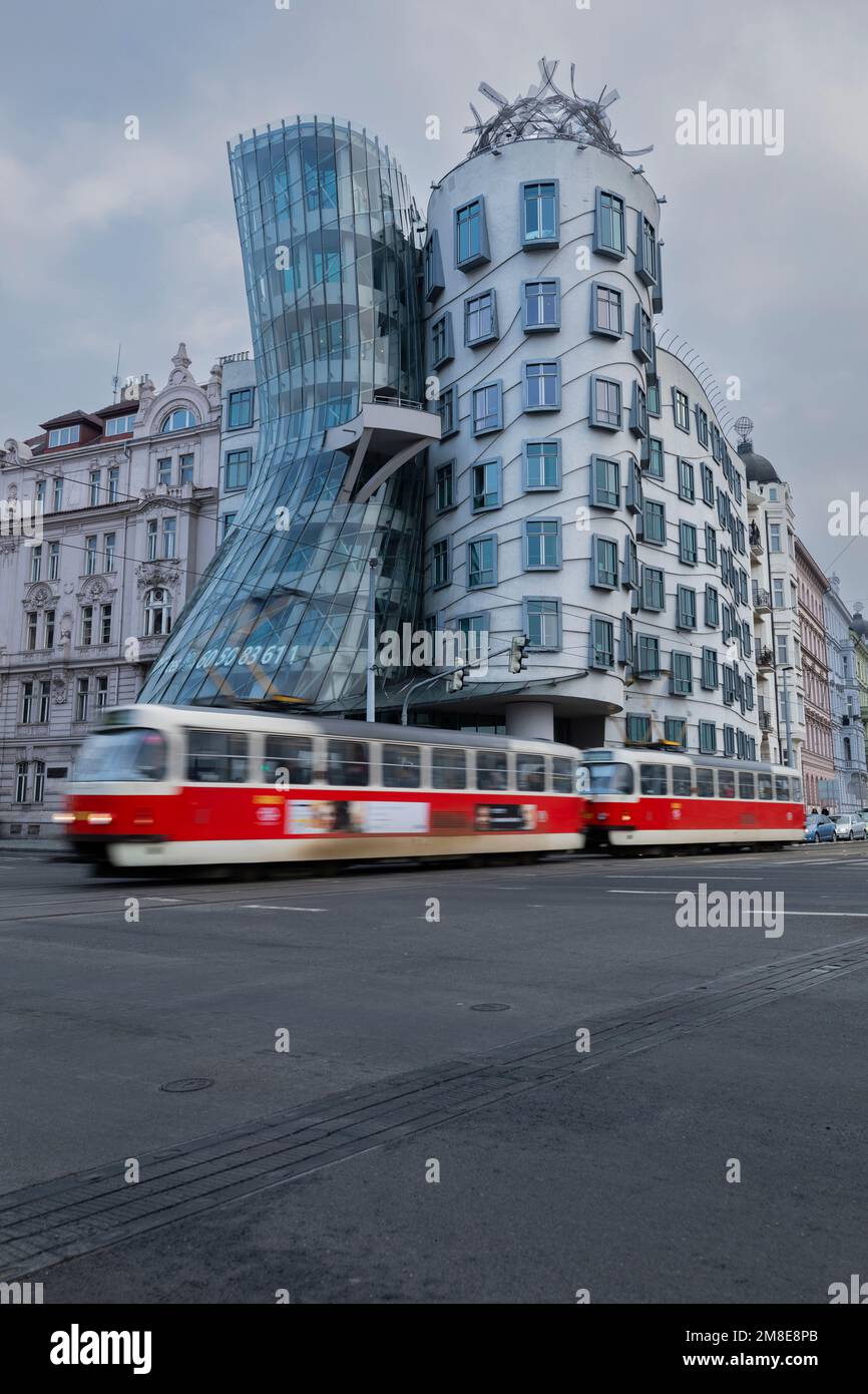 Tranvía rojo que se mueve frente a la Casa Danzante, Praga Foto de stock