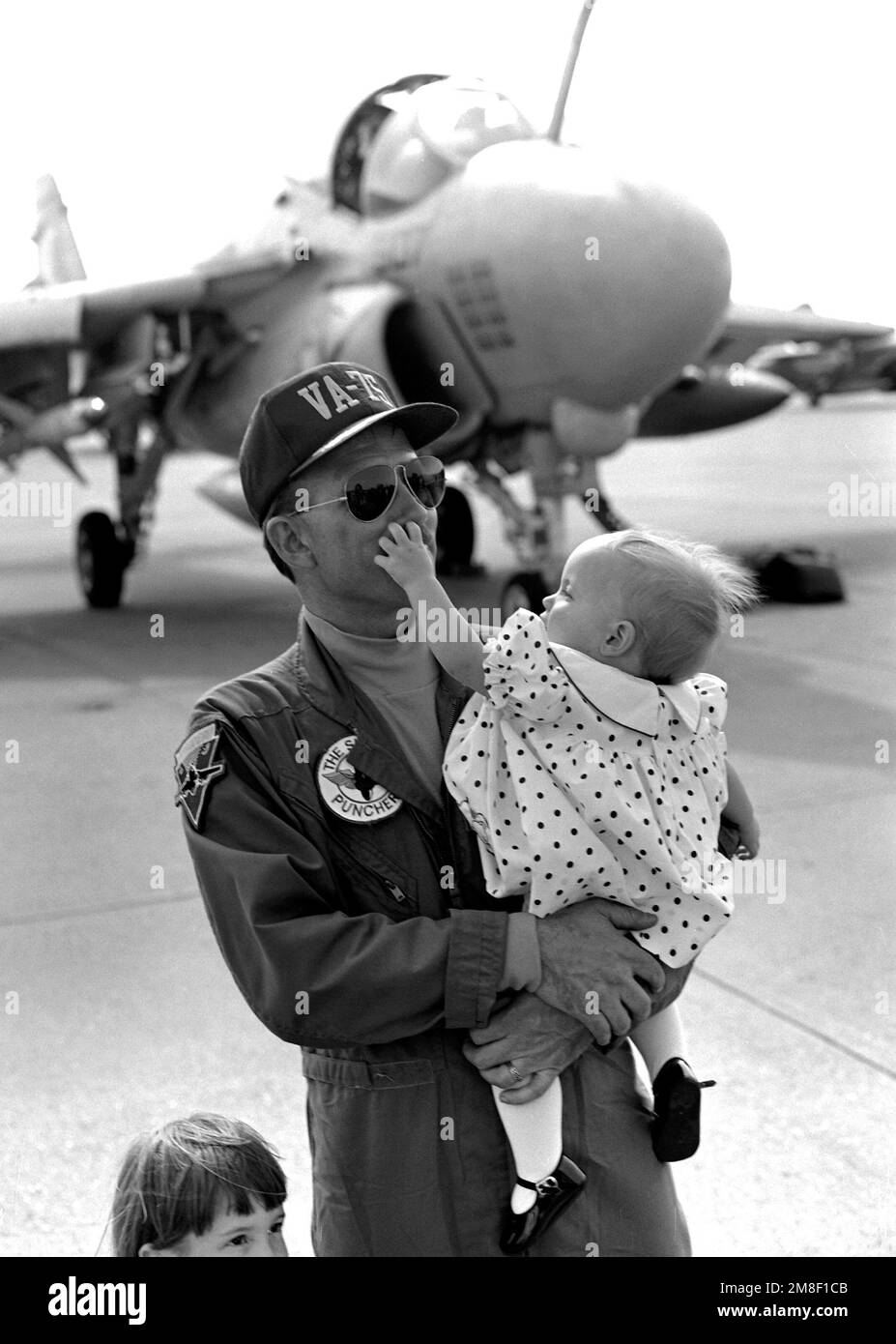 CMDR. Tom Hagan, oficial ejecutivo del Escuadrón de Ataque 75 (VA-75), sostiene a su hija a su llegada a la base. Los miembros de Carrier Air Wing 3 y Carrier Air Wing 17 regresan a casa después de servir en el Golfo Pérsico durante la Operación Tormenta del Desierto. Asunto Operación/Serie: TORMENTA DEL DESIERTO Base: Estación Aérea Naval, Oceana Estado: Virginia (VA) País: Estados Unidos de América (EE.UU.) Foto de stock