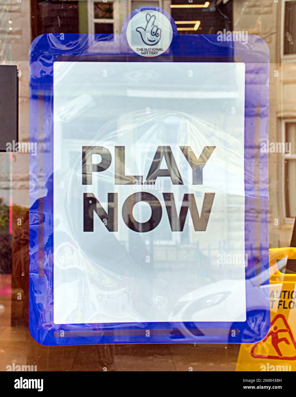 Lotería nacional jugar ahora cartel en la ventana de la tienda Foto de stock