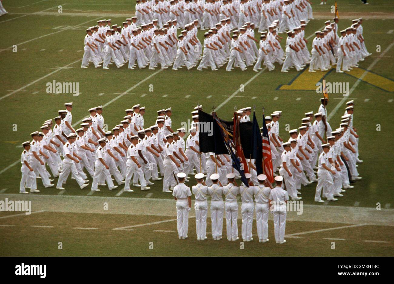 Un guardia de color se detiene mientras formaciones de marineros marchan en el campo de juego en el estadio conmemorativo de la Marina y el Cuerpo de Infantería de Marina durante el partido de fútbol entre los EE.UU Academia Naval y Bowling Green State University. Base: Annapolis Estado: Maryland (MD) País: Estados Unidos de América (USA) Foto de stock