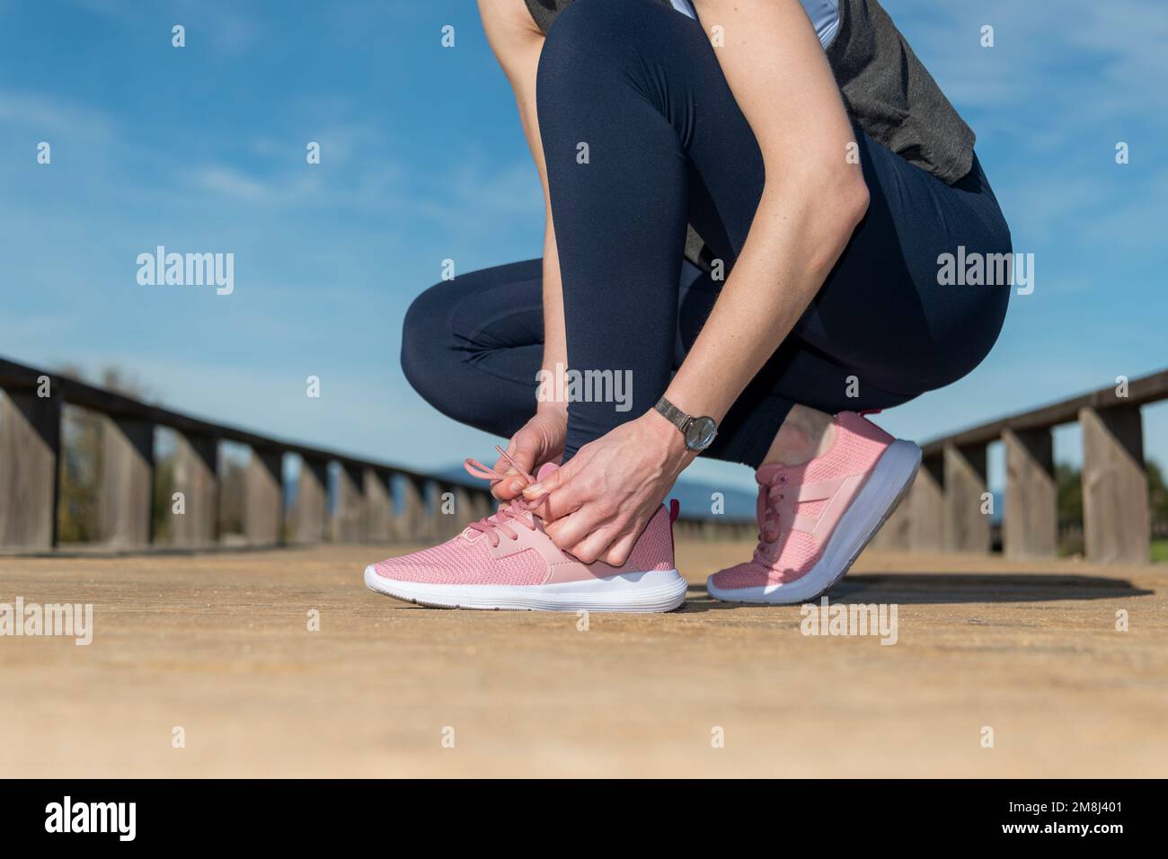 mujer atando cordones en zapatillas de running, preperación antes de correr. Foto de stock
