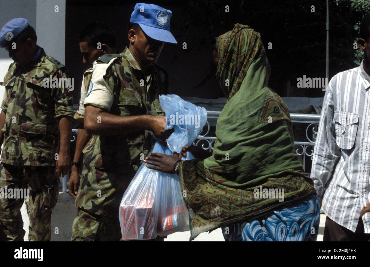 Los soldados nepalíes distribuyen comida a los residentes somalíes como parte de la celebración del cumpleaños de su rey. Los nepaleses celebran el cumpleaños de su Rey ayudando a los menos afortunados. Asunto Operación/Serie: UNOSOM II Base: Mogadiscio País: Somalia (SOM) Foto de stock