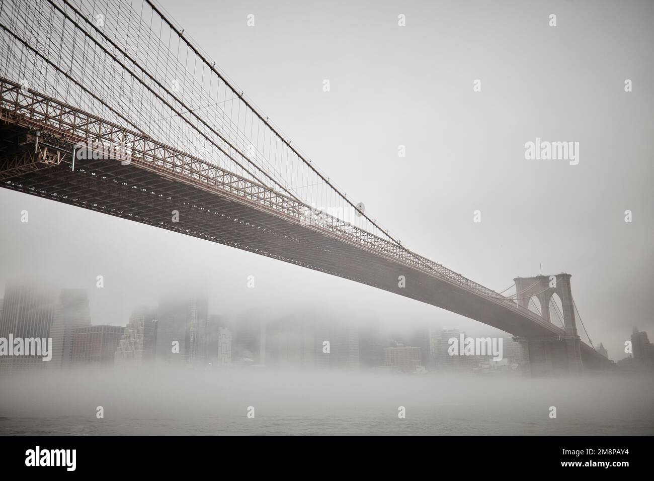 La ciudad de Nueva York Brooklyn Dumbo área con el emblemático puente de Brooklyn en la niebla que oculta el icónico horizonte Foto de stock