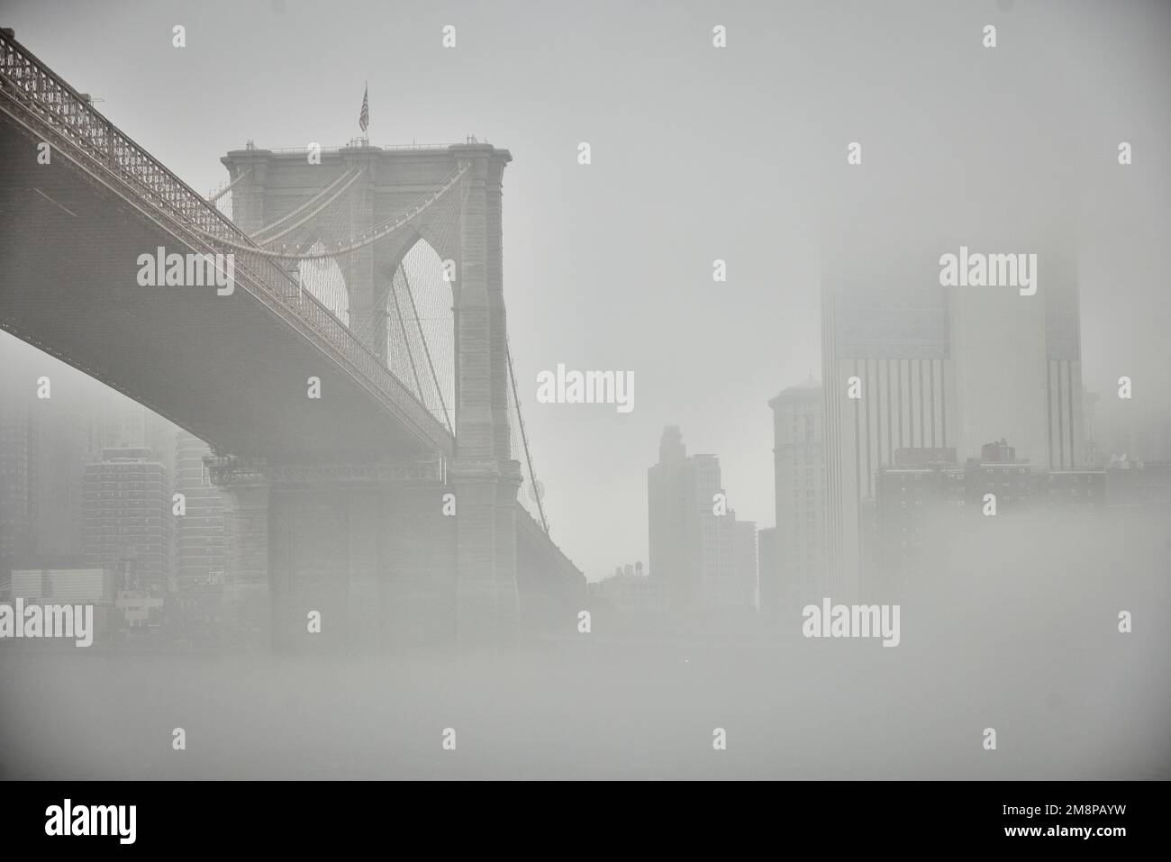 La ciudad de Nueva York Brooklyn Dumbo área con el emblemático puente de Brooklyn en la niebla que oculta el icónico horizonte Foto de stock
