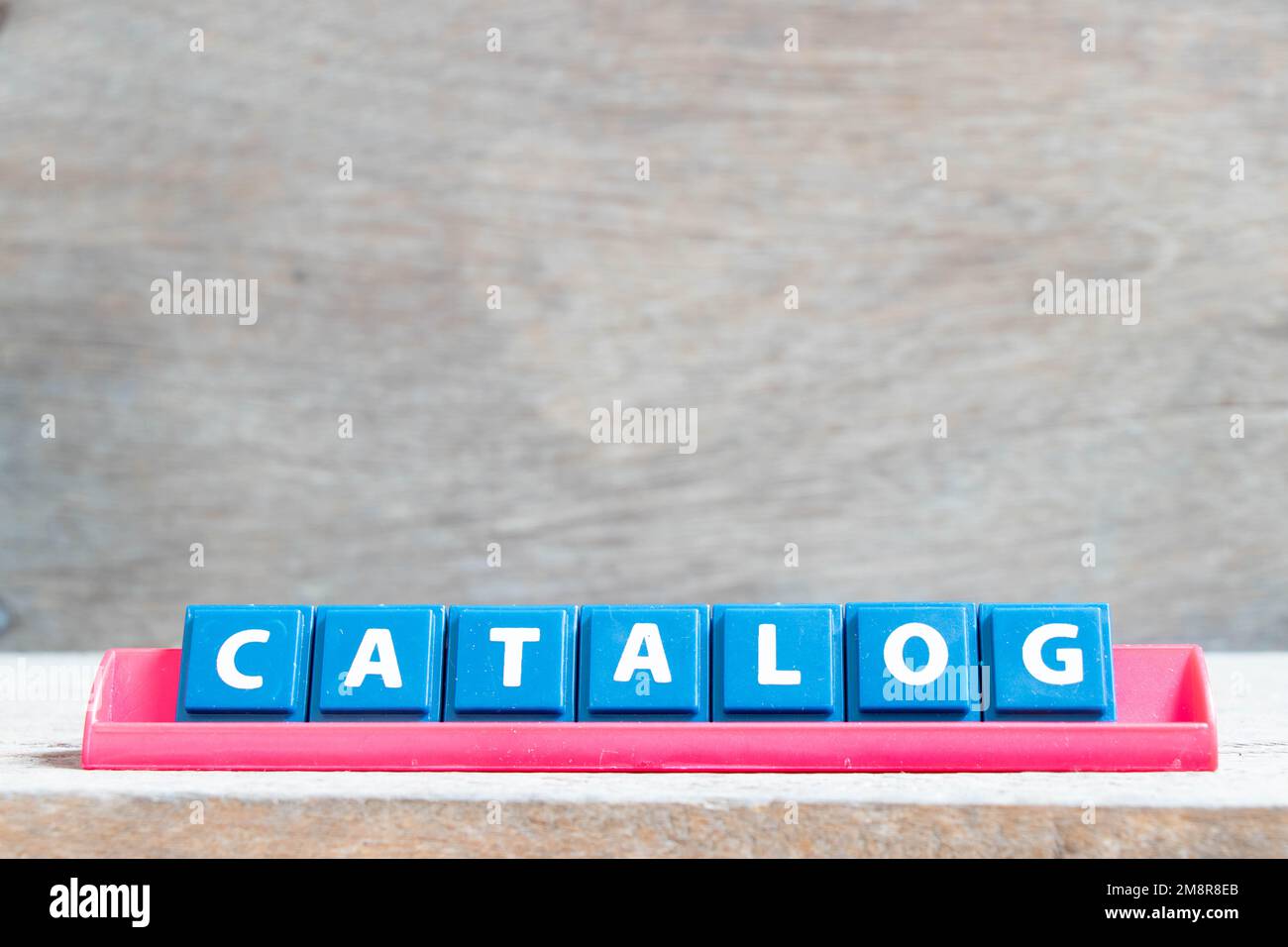 Letra del alfabeto del azulejo con el catálogo de la palabra en el estante  del color rojo sobre fondo de madera Fotografía de stock - Alamy