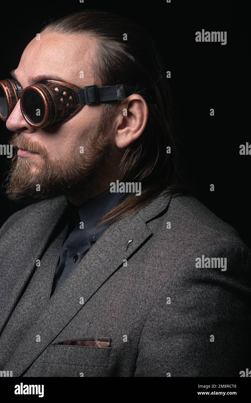 Hombre carismático en un traje clásico y gafas steampunk sobre un fondo  negro Retrato elegante Fotografía de stock - Alamy