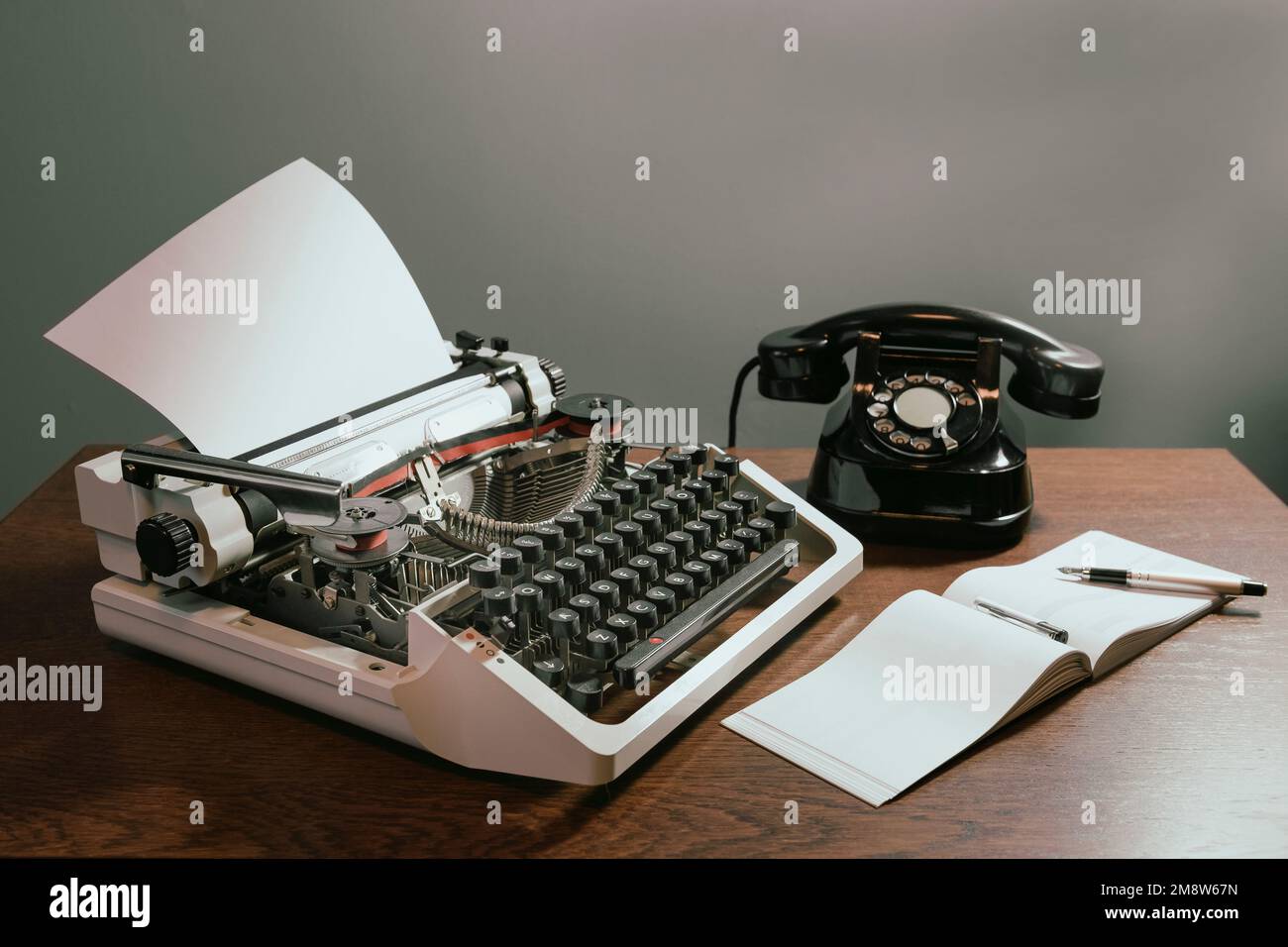 Talonario con una página en blanco. Concepto retro con teléfono viejo, pluma de tinta y máquina de escribir. en color Foto de stock