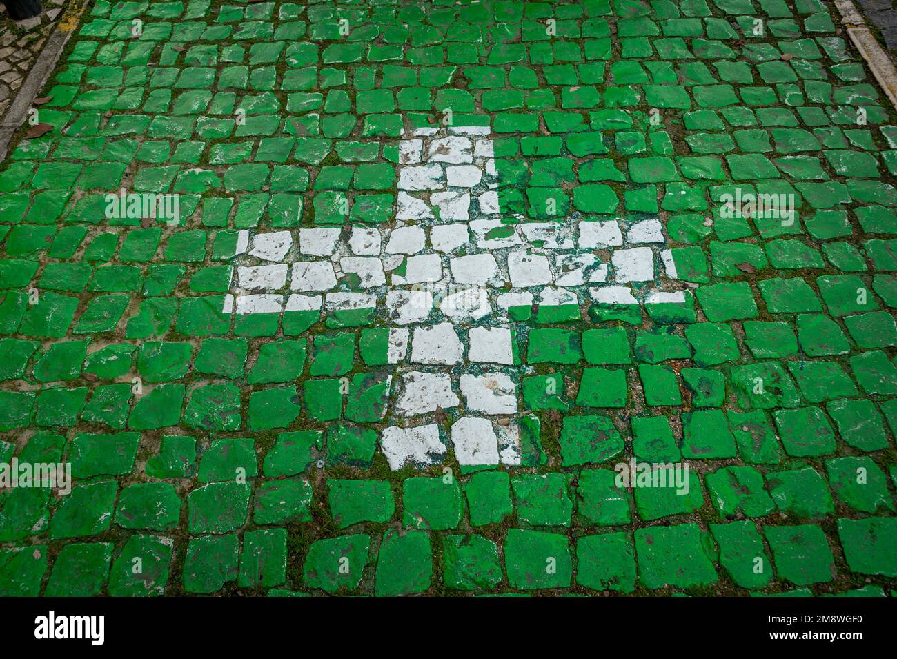 Cruz blanca sobre un fondo de azulejos verdes, aparcamiento de farmacia en Portugal. Foto de stock